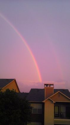 a rainbow is seen in the sky over houses