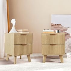 two nightstands side by side in front of a wall with a painting on it