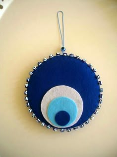 a blue ornament with an evil eyeball on it's side hanging from a cord