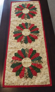 the table runner is decorated with red, green and white poinsettis