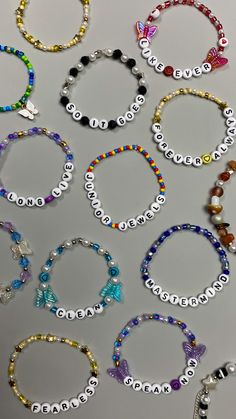 many different bracelets with name beads and charms on them, all in different colors