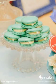 there are many cookies and macaroons on the cake stand next to each other