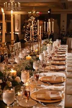 a long table set with place settings and candles in the background for a formal dinner