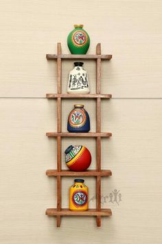 a wooden shelf with four different vases on it