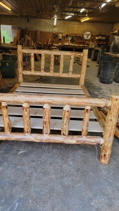 a bed frame made out of logs in a warehouse