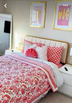 a bed room with a neatly made bed and two pictures on the wall above it