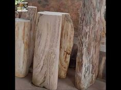 three wooden vases sitting next to each other in front of a stone wall and window