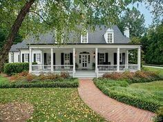 a white house surrounded by trees and flowers