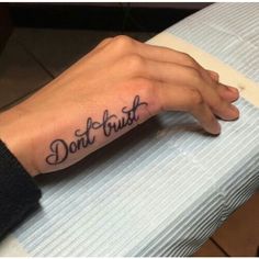 a person's hand with a tattoo that says don't trust