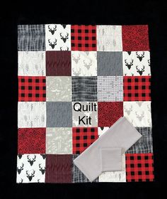 the quilt kit is made up of squares and plaids with deer heads on them