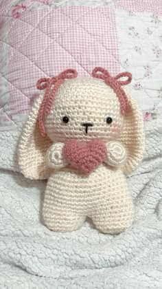 a crocheted stuffed animal sitting on top of a bed