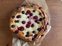 a cheesecake topped with cherries on top of wax paper