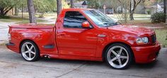 a red pick up truck parked on the street