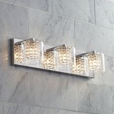 a bathroom light that is mounted on the side of a wall with lights in it