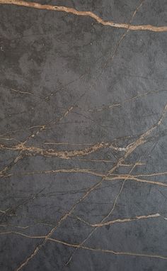 a black and gold marble textured surface with thin lines on the top right hand corner