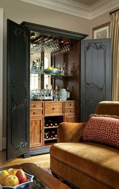 a living room filled with furniture and a wine glass cabinet in the middle of it