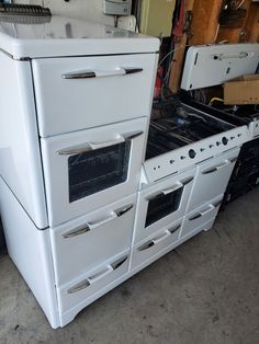 an old white stove and oven in a garage