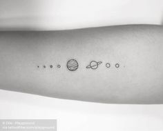 the planets tattoo on the arm is shown in this black and white photo, it has three