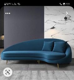 a blue couch sitting on top of a floor next to a white and black wall