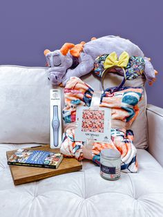 an assortment of items sitting on top of a white couch