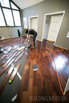 a man is working on installing wood flooring