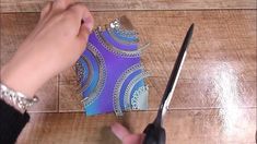 someone cutting paper with scissors on a wooden table