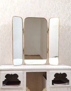 a white shelf with three mirrors on it