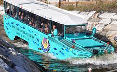 a tour bus with people on it going through the water