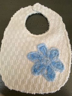 One baby bib made from a Vintage Cotton Chenille and an Appliqued Blue Chenille Flower.  This bib is backed with blue chenille.   Bib has a strong Velcro closure. Measurements:  8.5in wide and from top of bib to bottom 11.5in.  Neck opening measures 11in to 11.5 in around. Additional bibs are posted. I seek for 100% customer satisfaction so please reach out with questions, I'm happy to help. Thank you for visiting the store and please return as more things are listed regularly. Cute Handmade White Bib, Cute White Handmade Bib, Cute Blue Bib For Playtime, Blue Cotton Machine Washable Bib, Blue Cotton Bib For Playtime, Chenille Flower, Vintage Chenille, Flower Applique, First Baby