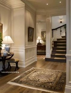 an entry way with stairs and rugs on the floor