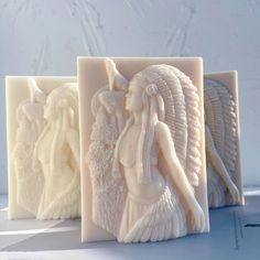 two white soaps with carved images on them