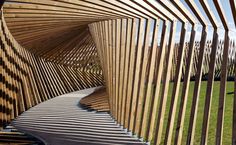 a wooden structure with wavy lines on the side and grass in the backround