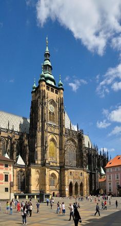 many people are walking around in front of an old building