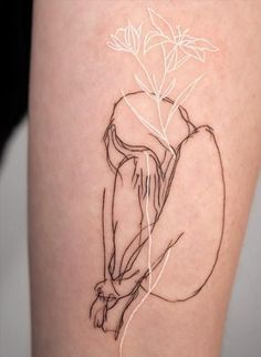 a woman's thigh with a line drawing of a flower on the lower leg