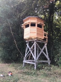 a tall wooden tower sitting in the middle of a forest