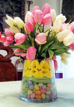 a vase filled with candy and flowers on top of a table