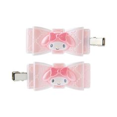 two pink hair clips with hello kitty bows on each one's head and an embellishment in the middle