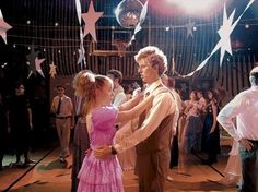 a man and woman dance together on the dance floor in front of a group of people