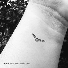 a black and white photo of a small tattoo on the wrist