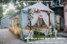 an outdoor wedding tent decorated with flowers and greenery