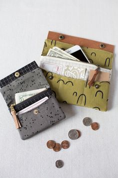 two small wallets with money and cell phones in them sitting next to each other