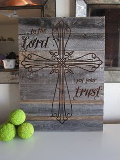 two green balls sitting on top of a table next to a wooden sign that says put the lord in your trust