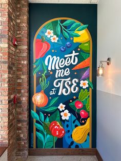 a painted door with the words meet me at 198 on it and vegetables in front