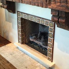 a fireplace in a room with tile and wood trimmings on the mantle above it