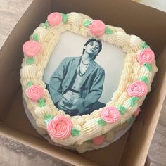 a cake in a box decorated with an image of a man and flowers on it