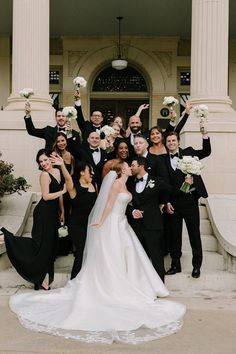 a group of people in tuxedos pose for a photo outside the entrance of a building