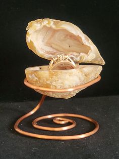 a piece of jewelry sitting on top of a metal stand with a ring in it