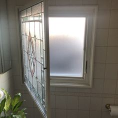 a bathroom with a toilet, sink and stained glass window