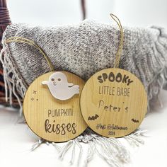 two wooden tags with the words spook, little babe, and pumpkin kisses written on them