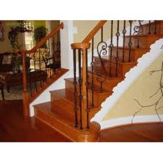 a wooden staircase with wrought iron railing and handrail